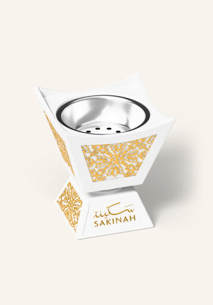 Close up of the white and gold Hijaz bakhoor burner with an Arabic floral pattern and removable inner metal cup, part of the Sakinah Ritual bakhoor gift set