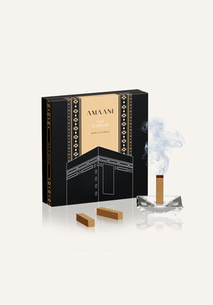 Amaani Oud Al Kiswah premium oud bricks with incense burning and elegant black and gold Islamic gift packaging