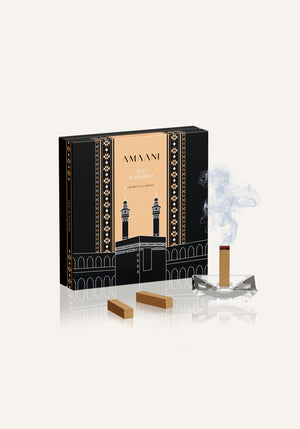 Amaani Oud Al Kaabah premium oud bricks burning in crystal bakhoor burner beside black and gold gift box